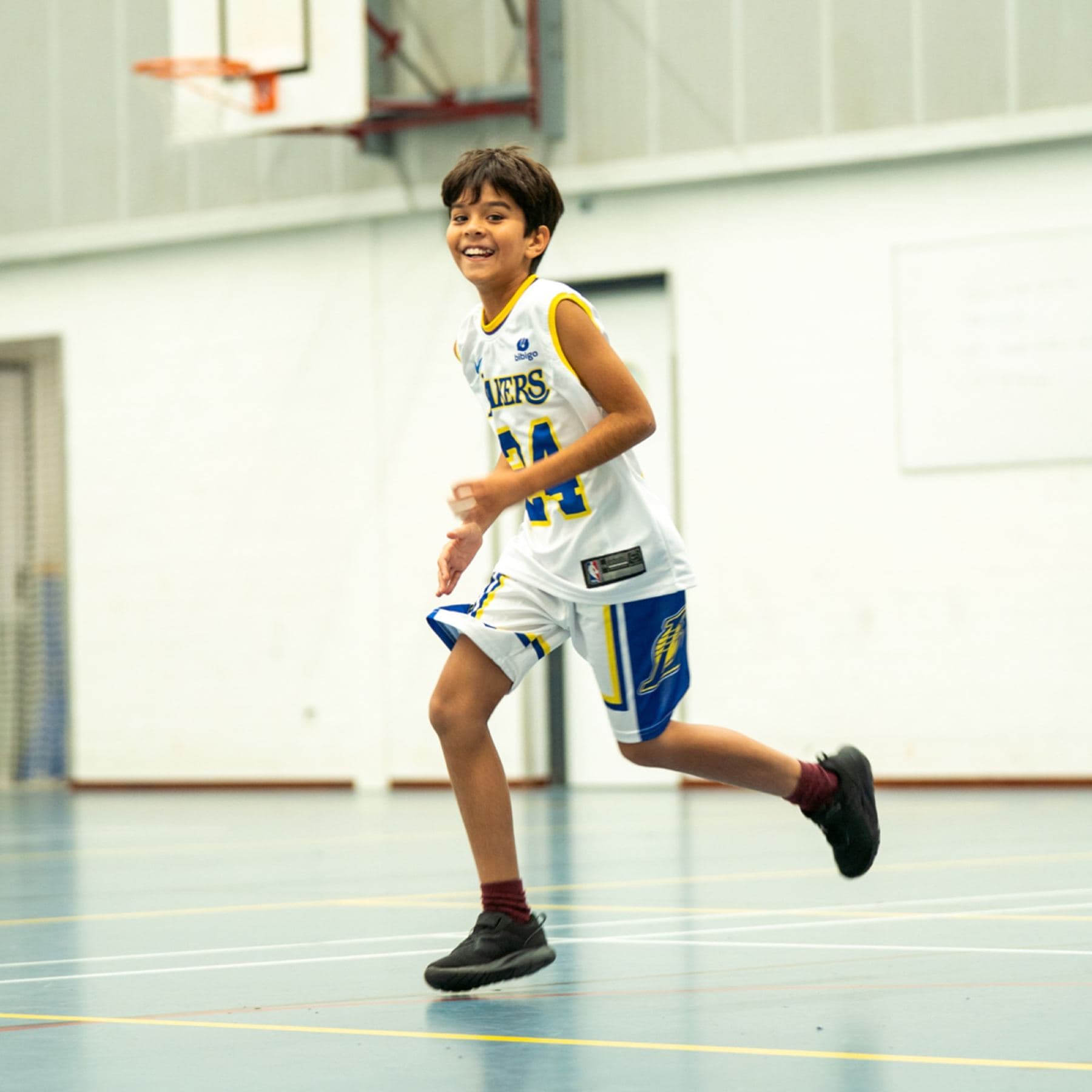 Jonge speler rent lachend over het veld