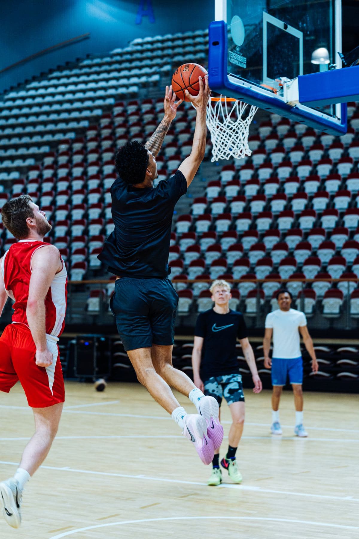 Speler legt de bal in de basket tijdens een training in een arena