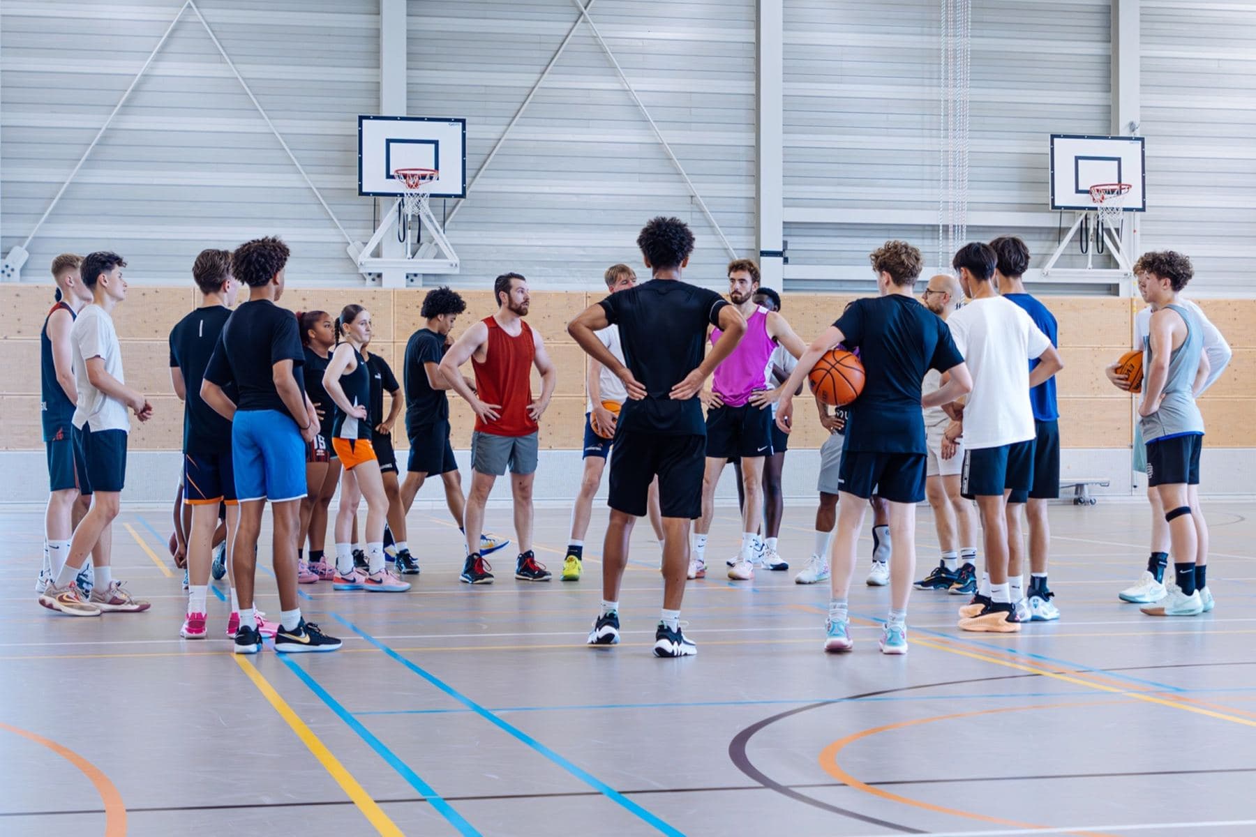 Spelers in een huddle rond de coach tijdens de training